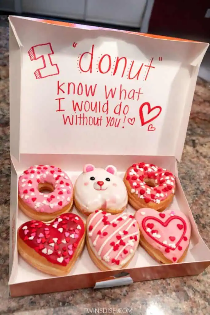 Valentine’s Day donut gift box with heart-shaped donuts, pink and red frosting, cute bear donut, and handwritten “I donut know what I’d do without you” message inside the box
