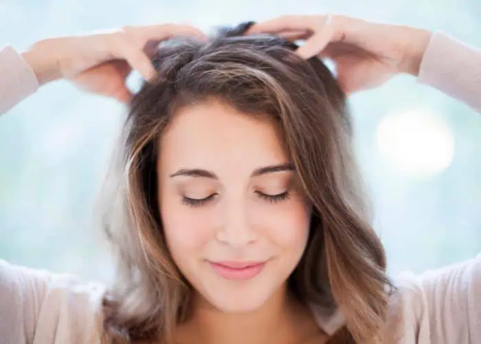 woman massaging her scalp for hair growth