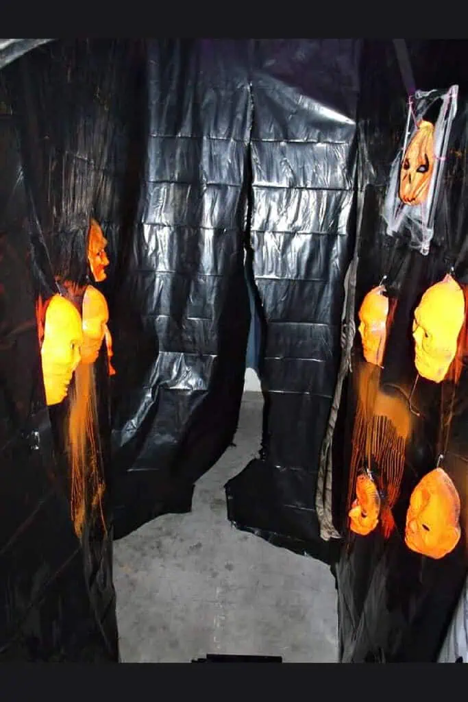 Easy DIY Cheap Faux Walls for a Halloween Haunted House made out of large garbage bags and dollar store masks.