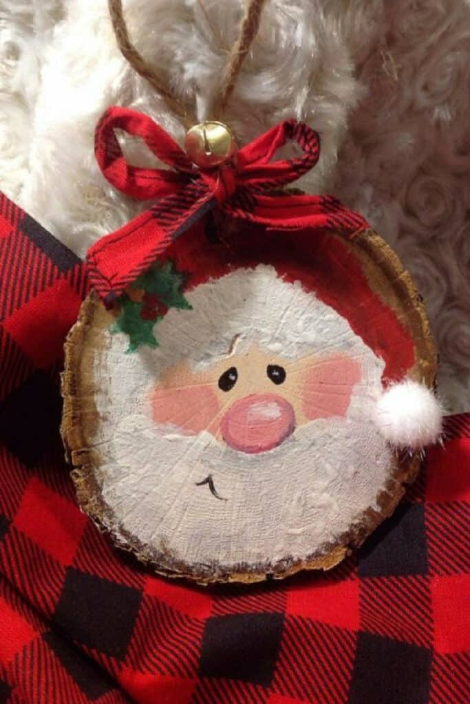 Painted Santa face vintage wood slice Christmas ornament with a buffalo check red bow and bell