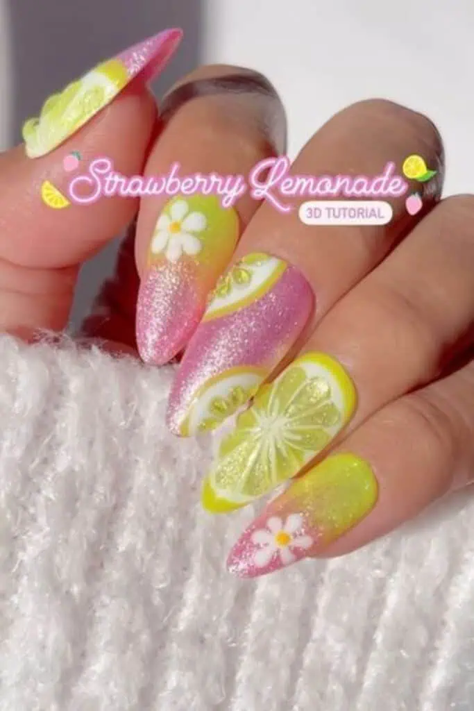 Close-up of vibrant strawberry lemonade 3D jelly nails featuring a pink-to-yellow glitter ombré base, realistic translucent lemon slice designs, and white daisy flowers, perfect for summer or end-of-summer nail inspiration.