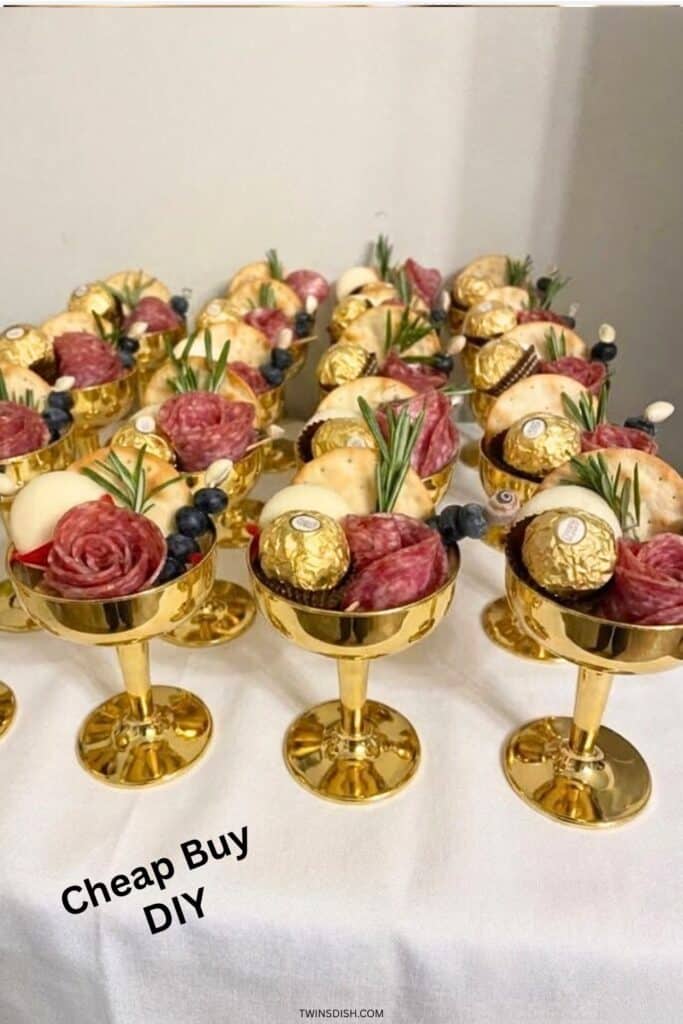 Graduation party charcuterie cups with salami roses, cheese, crackers, blueberries, and chocolates in gold cups”