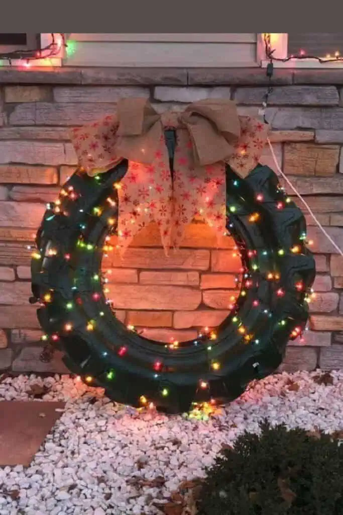 Upcycled Tire wreath Outdoor country Christmas decor with lights and a bow