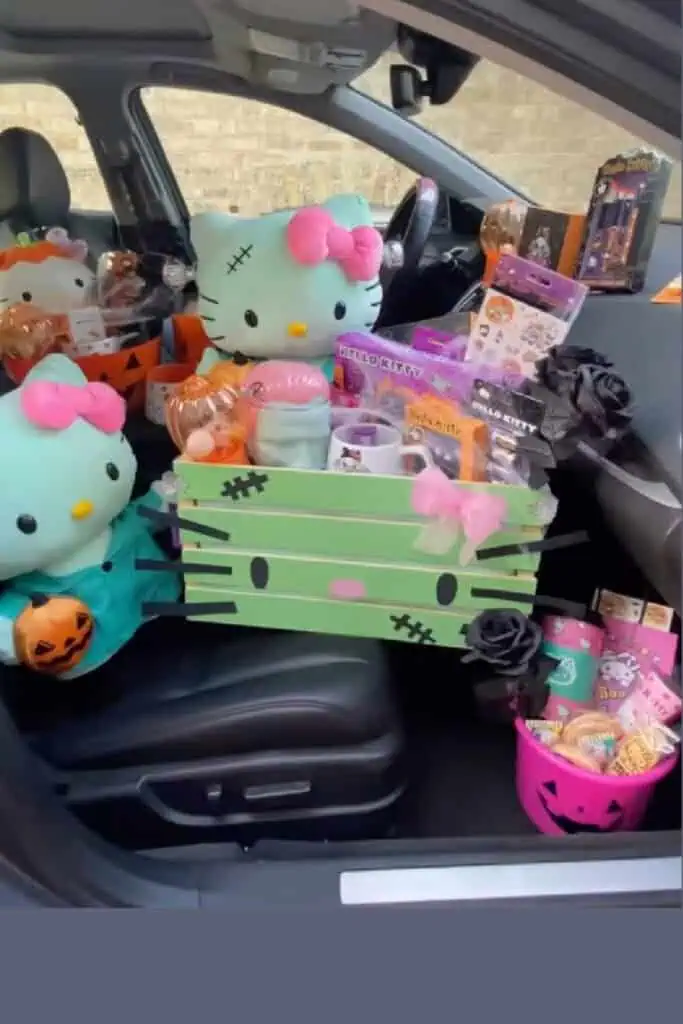 Car filled with Hello Kitty-themed Halloween boo baskets, including plush toys, pumpkin buckets, spooky treats, and pink, black, and orange decor. A creative and aesthetic DIY boo basket idea for 2025, perfect for kids, teens, or Hello Kitty fans.