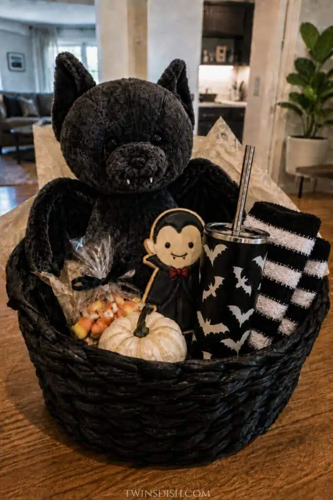 Halloween boo basket with a black bat plush, vampire cookie, bat tumbler, striped fuzzy socks, candy corn and mini pumpkin.