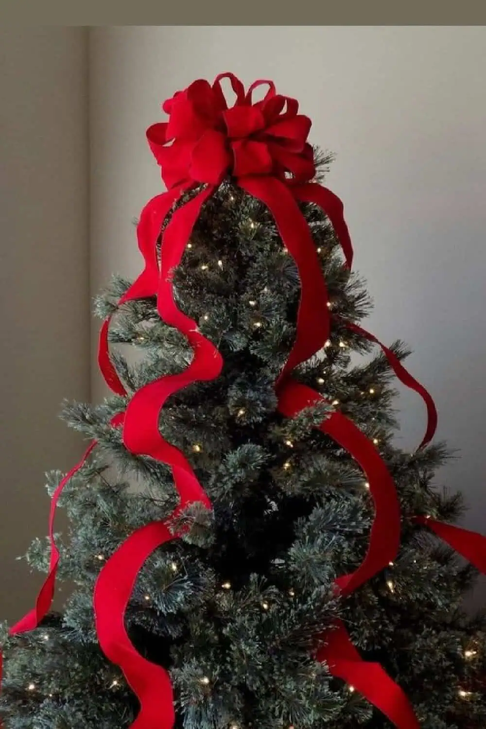 Red bow on top of Christmas tree