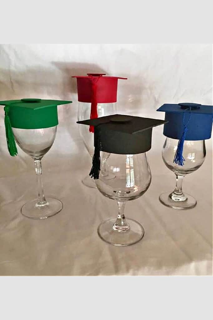 Graduation cap wine glass centerpieces in black, blue, red, and green