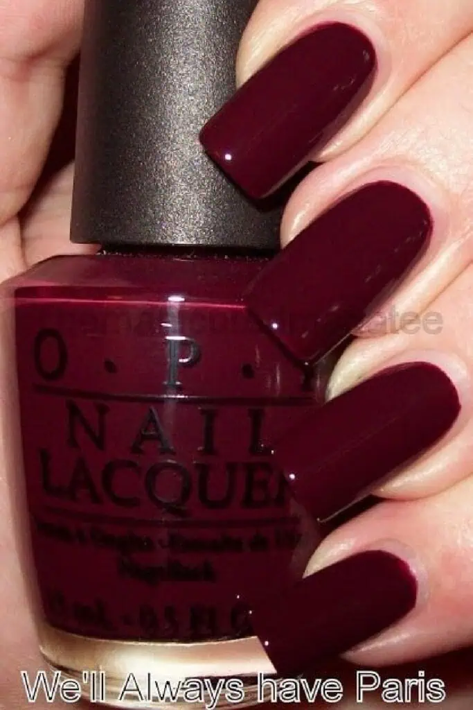 Close-up of long square-shaped nails painted in deep burgundy OPI nail polish shade 'We’ll Always Have Paris' – a rich autumn and fall nail color.