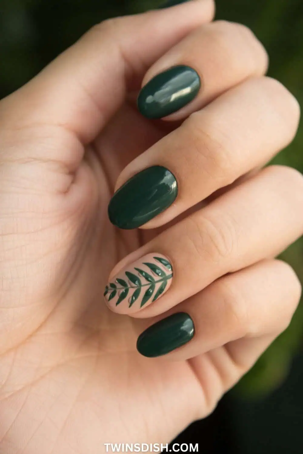 Dark green muted jewel tone early fall nails with leaf design on ring finger