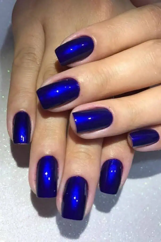 Metallic cobalt blue nails with glossy square shape, bold jewel-tone manicure perfect for fall 2025 nail trends and winter fashion.