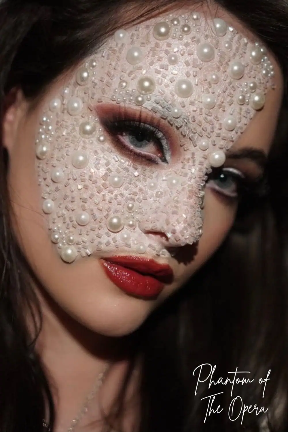 Close-up of Phantom of the Opera Halloween makeup with a pearl-covered half mask, smoky eye shadow, and red lipstick.