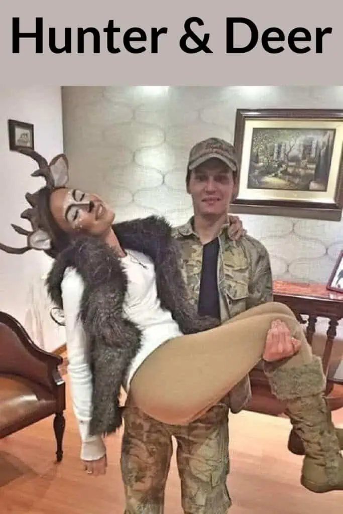 Hunter and deer couple costume featuring a man in camouflage as the hunter holding a woman dressed as a deer with antlers, faux fur vest, tan leggings, and deer makeup.
