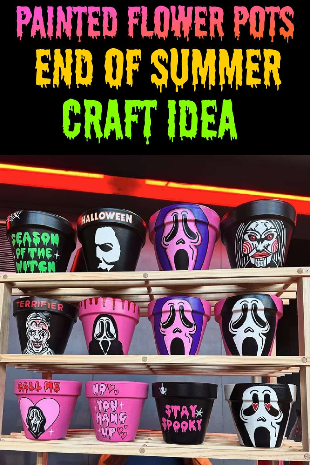 A wooden display shelf filled with colorful Halloween painted flower pots decorated with horror movie designs and sayings, including Ghostface, Michael Myers, Jigsaw, Terrifier, and fun phrases like “Stay Spooky” and “Call Me,” in black, pink, purple, and red color schemes. A perfect end of summer craft to kick off fall decorating.