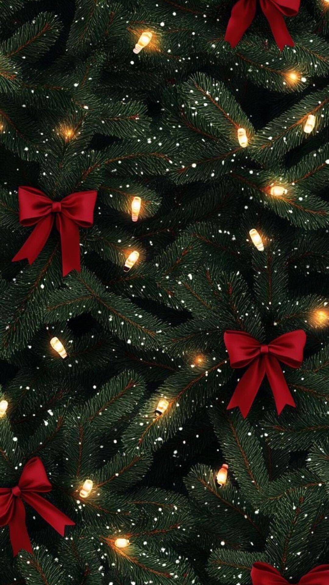 Classic Christmas iPhone wallpaper with green pine branches, glowing string lights, red bows, and falling snow for a festive holiday background.