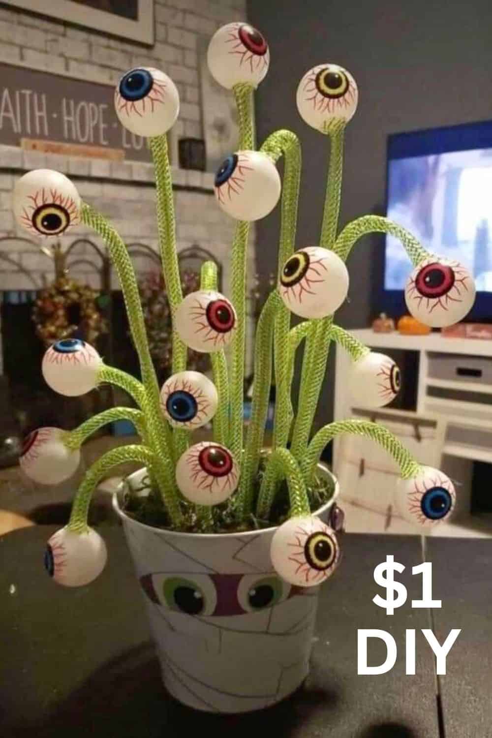 DIY eyeball plant made with Dollar Tree mesh tubing “stems” and plastic eyeballs in a small flower pot—fast, cheap Halloween centerpiece for parties or mantels.