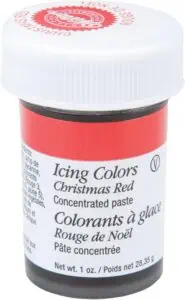 Red concentrated icing color paste labeled “Icing Colors Christmas Red” in a small plastic jar with a white screw-top lid.