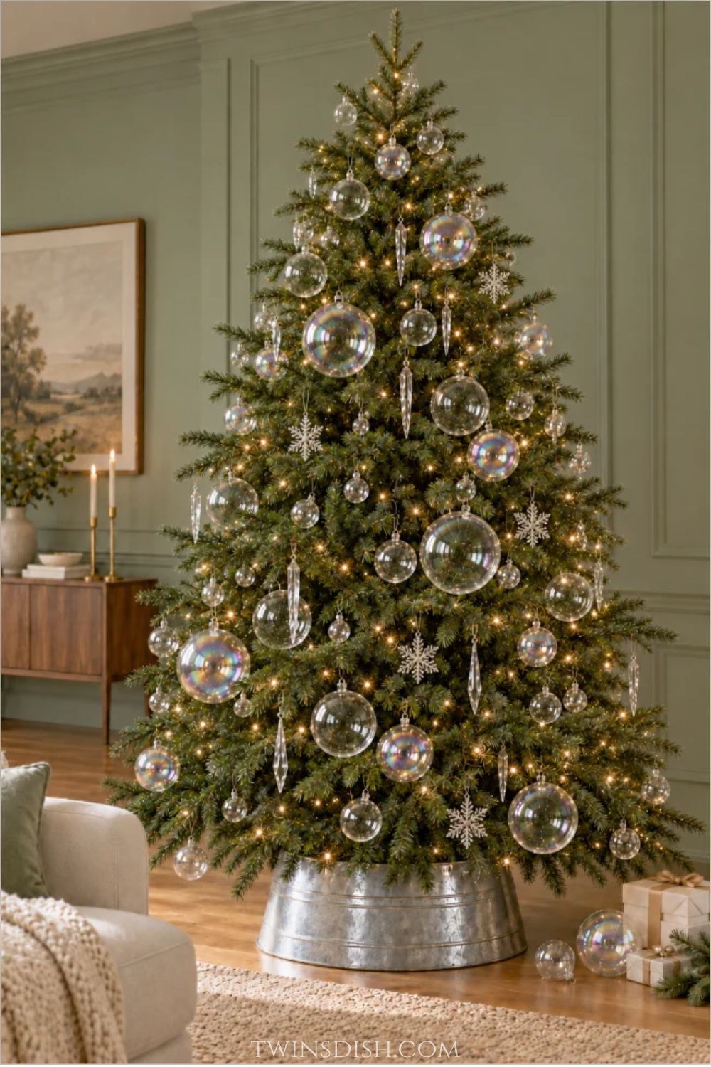 Natural green Christmas tree decorated with clear glass and iridescent soap bubble ornaments in varying sizes, crystal snowflakes, hanging crystal icicles, and warm white lights in an elegant living room.