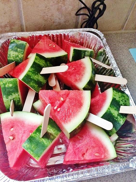 Easy DIY 4th of July party ideas for serving fruit. Put watermelon triangles on a stick.