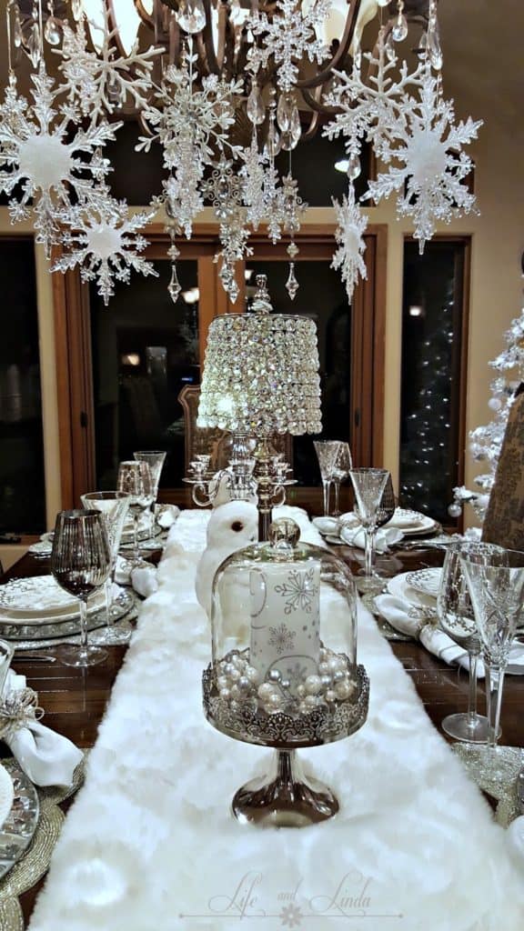 Easy DIY hanging snowflake chandelier winter decor idea using dollar store snowflakes and ribbon. Elegant Christmas decoration idea for mantle, window, ceiling, or wall. Great budget decor idea for the home, winter wedding, or Christmas party.