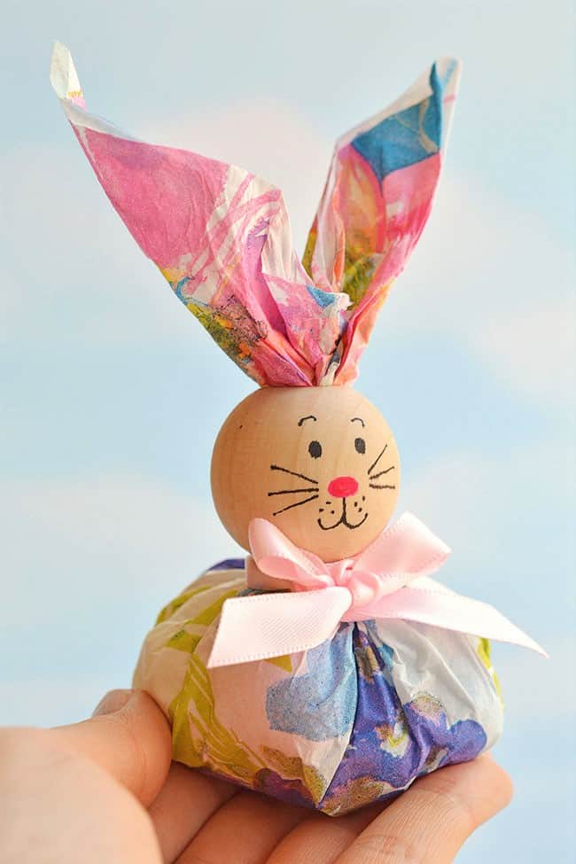 Easy DIY Paper Napkin Bunny Favors for kids using dollar store Items. The Best Easy DIY Easter Craft Decoration Ideas for a table or treat using a napkin and wooden bead.