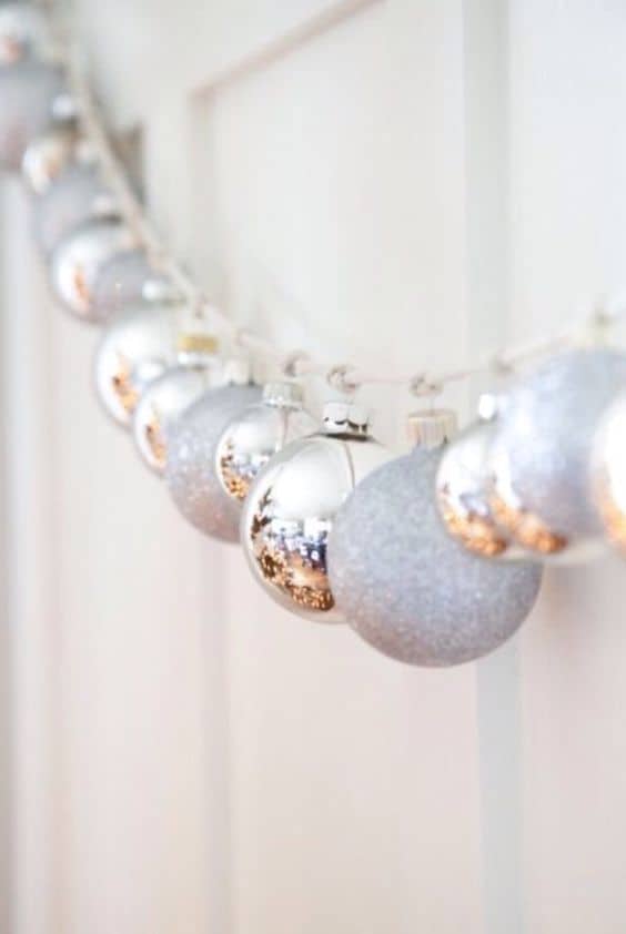 Easy DIY Christmas Garland idea on mantle or staircase using silver ornaments and string or ribbon. Elegant, budget home decor.