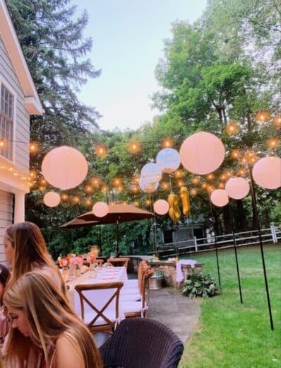 Lanterns and lights create a beautiful outdoor graduation party scene