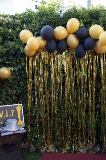 Easy DIY Graduation party decorations and picture ideas. Two cheap and easy methods for making a gorgeous photo backdrop or photo booth using dollar store streamers and balloons in black and gold.