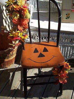 Pumpkin face painted on wood porch chair