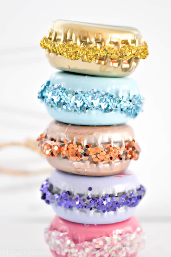 Easy DIY Glittery Macaron Ornaments That Look Professional and you'll actually want to keep. They're made with Paint, bottle caps, glitter and glue. An adorable craft or gift idea.