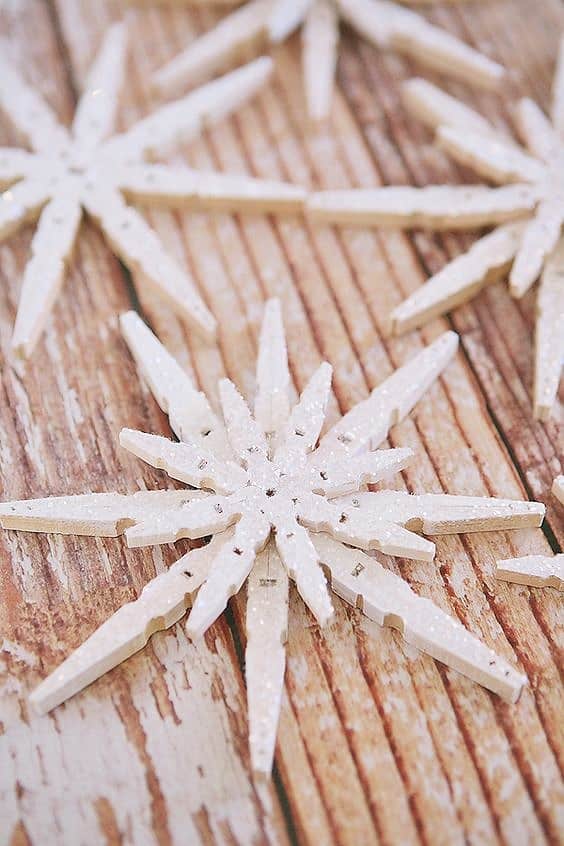 Easy DIY Popsicle Snowflake Christmas Ornament or Winter decoration. Simple yet beautiful dollar store craft gift idea anyone can make, even kids. Leave plain for a rustic farmhouse Christmas decoration or ornament or dress it up with paint, glitter, and rinestones. for elegant decor