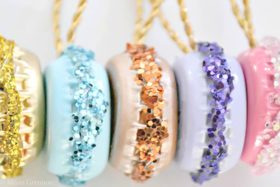 Easy DIY Glittery Macaron Ornaments That Look Professional and you'll actually want to keep. They are made with bottle caps, glue, glitter, and paint. An adorable craft or gift idea.